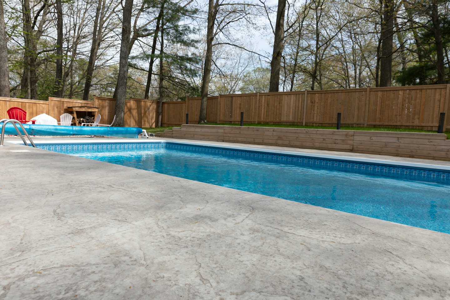 Una piscina con tumbonas junto a un patio.