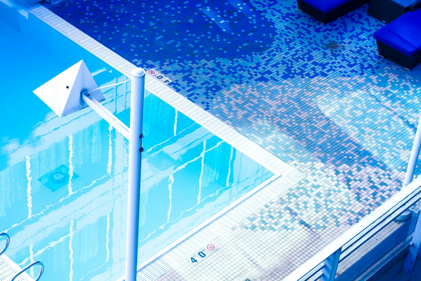 Piscina moderna de agua azul con bordes de azulejo.