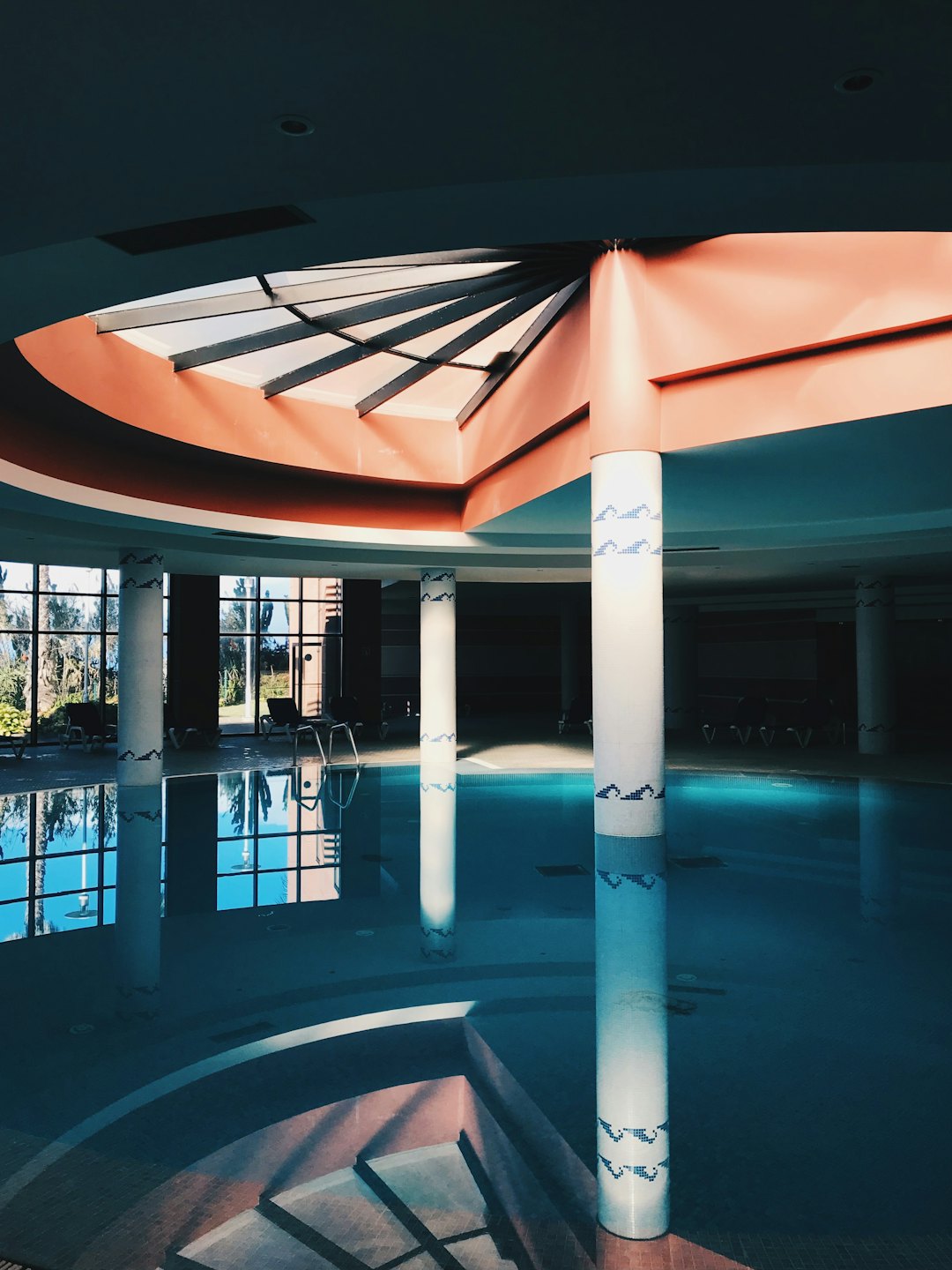 Piscina circular vacía con altos pilares decorativos blancos.